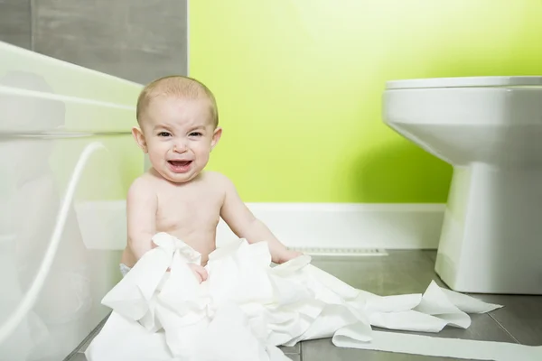 Toddler ripping up toilet paper in bathroom — Stock Photo, Image