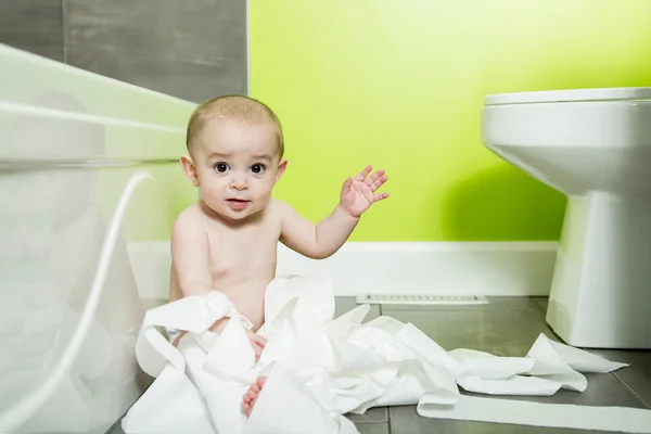 Toddler ripping up toilet paper in bathroom — Stock Photo, Image