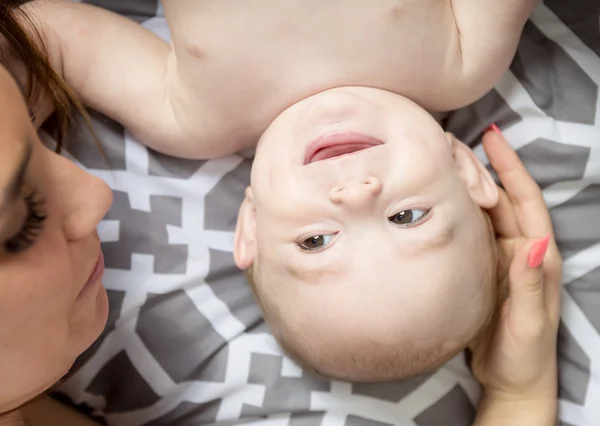 Retrato de madre joven y feliz con un bebé en la cama en casa — Foto de Stock