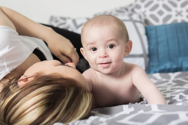 Ritratto di giovane madre felice con un bambino nel letto di casa — Foto Stock