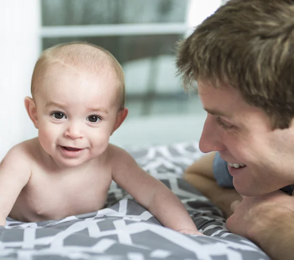 Ritratto di giovane padre felice con un bambino nel letto di casa — Foto Stock