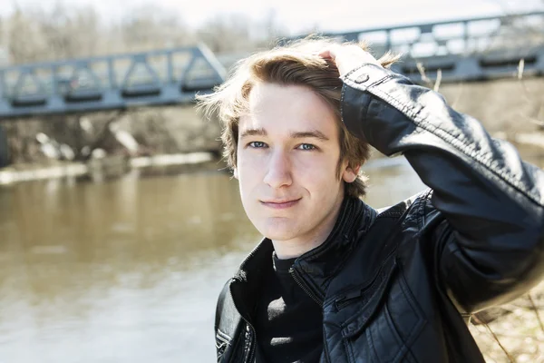 Adolescente senta-se fora perto de uma ponte jaqueta de couro . — Fotografia de Stock