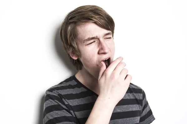 Стоя усталый молодой человек зевает и растягивается — стоковое фото