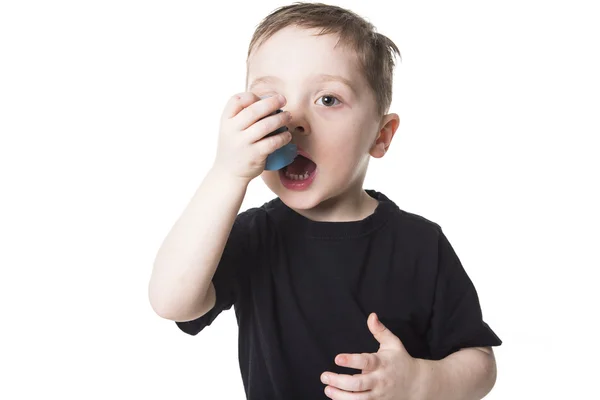 Pojke 4 år gammal andas in sig själv på en vit bakgrund — Stockfoto