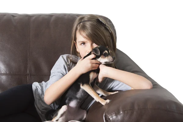 Szczęśliwa dziewczyna z psem na kanapie — Zdjęcie stockowe