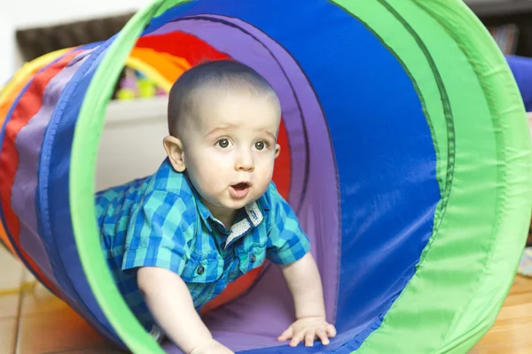 Adorable little boy playing inside a toy tunnel — Stock Photo, Image