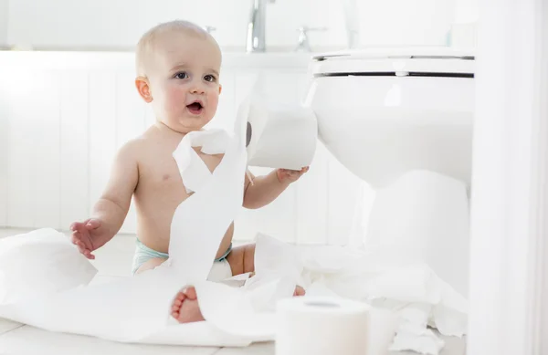 Förtjusande baby pojke leker med toalettpapper — Stockfoto