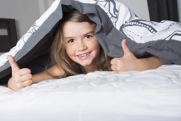 Дитина або підліток під обкладинками в ліжку — стокове фото