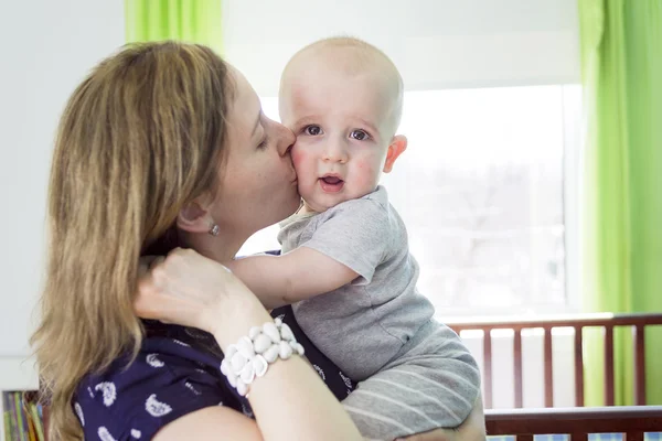 Happy mother with her baby boy at home in bedroom — Stock Photo, Image