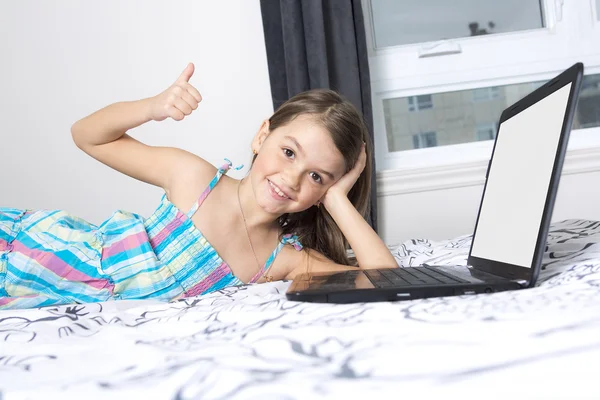 Nine years old child having fun using laptop at her bedroom — Stock Photo, Image