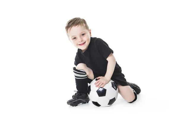 Милий хлопчик тримає футбольний м'яч ізольовано на білому тлі. Футбол — стокове фото