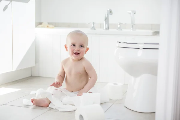 Adorável menino brincando com papel higiênico — Fotografia de Stock