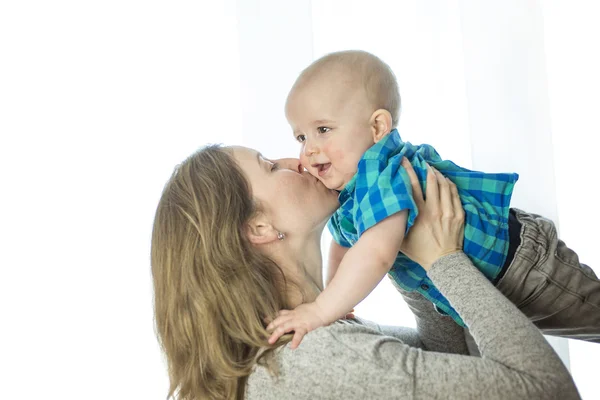 Loving mother playing with her baby close to a window — Stock Photo, Image