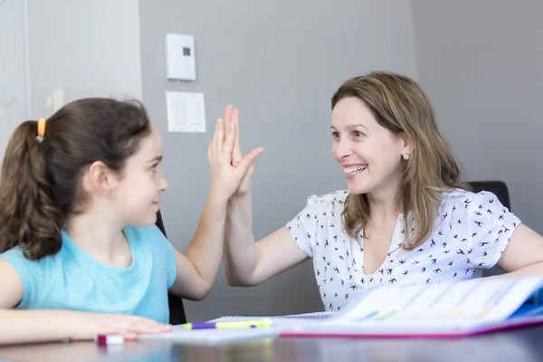 Mature mother helping her child with homework at home. — Stock Photo, Image