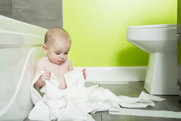 Toddler ripping up toilet paper in bathroom — Stock Photo, Image