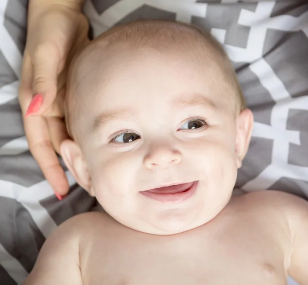 Portrait of happy young mother with a baby in the bed at home — Stock Photo, Image