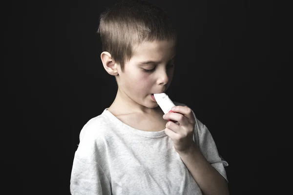 Imagen de cerca de un niño lindo usando inhalador para el asma . — Foto de Stock