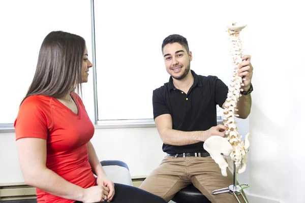 Vrouwelijke patiënt beschrijven praten met letsel osteopaat — Stockfoto