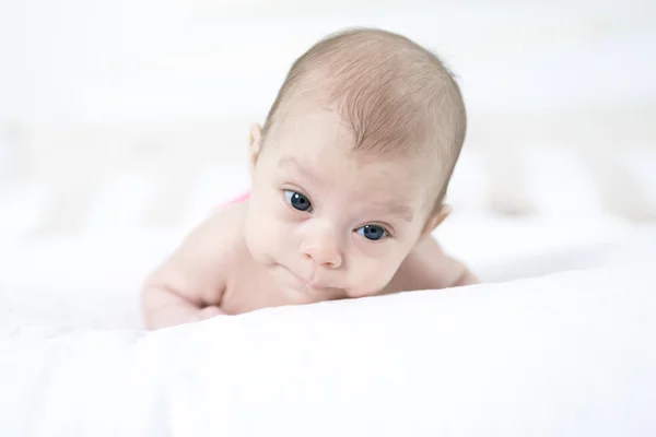 Linda chica de dos meses de edad, acostada en la cama —  Fotos de Stock