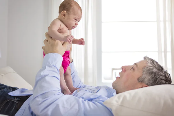 Father and is two months old baby in bed at home — Stock Photo, Image