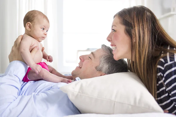 Parents Cuddling Newborn Baby In Bed At Home — Stock Photo, Image
