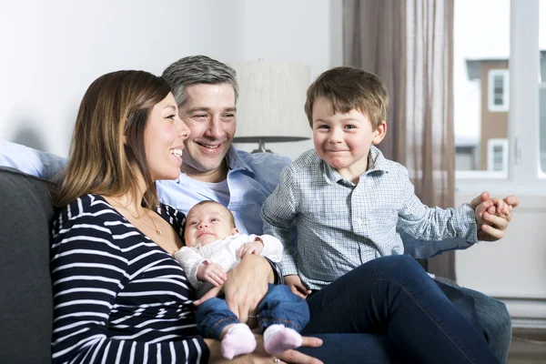 Família feliz mãe, pai e dois filhos em casa — Fotografia de Stock