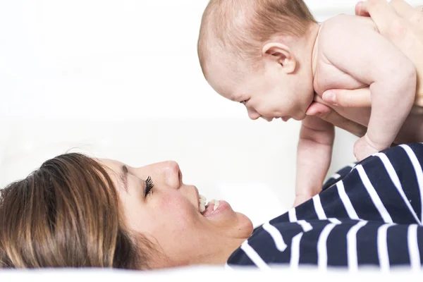 Mom with her daughter laying on the bed — Stock Photo, Image