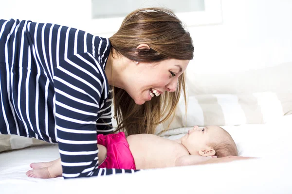 Mom with her daughter laying on the bed — Stock Photo, Image