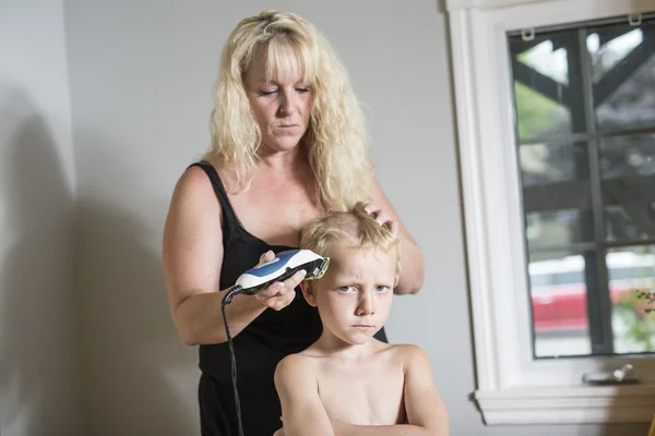 Moeder snijden haar van haar zoontje — Stockfoto