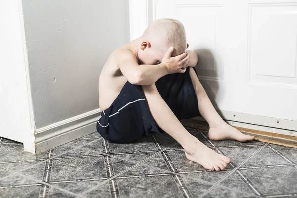 Opomíjené osamělé dítě se na zeď — Stock fotografie