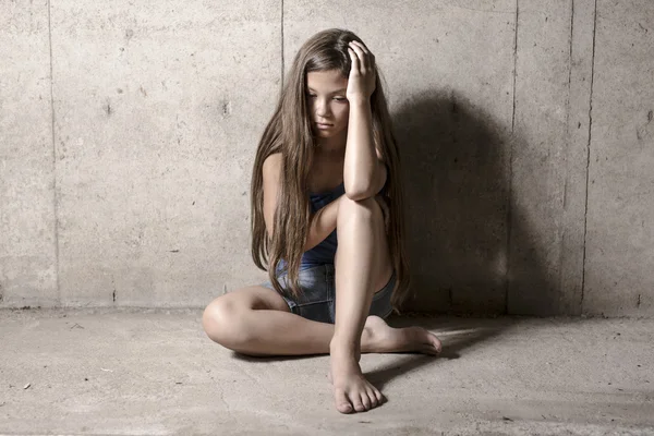 Chica triste y solitaria al lado de la pared — Foto de Stock