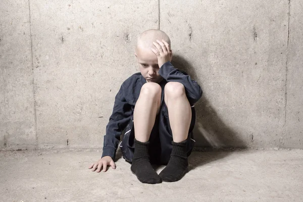 Niña solitaria abandonada apoyada en la pared —  Fotos de Stock