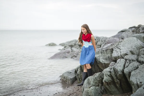 Dívka se těší déšť a baví venku na pláži gray deštivé — Stock fotografie