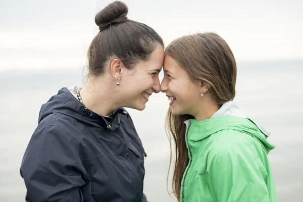 Família desfrutando da chuva e se divertindo lá fora na praia uma chuva cinza — Fotografia de Stock