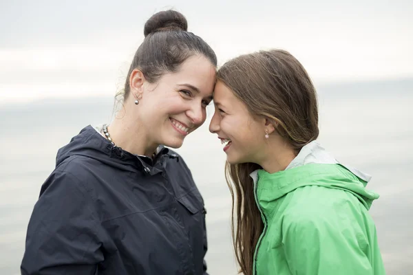 Family enjoying the rain and having fun outside on the beach  a gray rainy — Stock Photo, Image