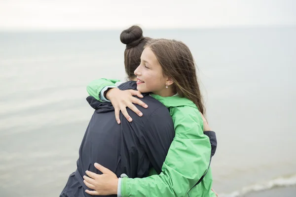 Family enjoying the rain and having fun outside on the beach  a gray rainy — Stock Photo, Image