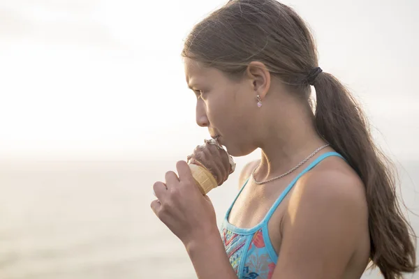 Wanita makan es krim lezat saat matahari terbenam . — Stok Foto