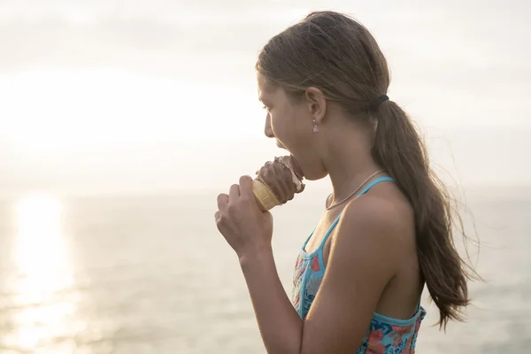 Wanita makan es krim lezat saat matahari terbenam . — Stok Foto