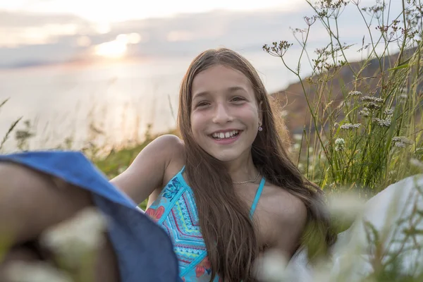 Tonåring flicka vid solnedgången på sidan av havet — Stockfoto