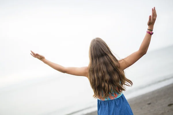 Chica disfrutando de la lluvia y divertirse al aire libre en la playa un gris lluvioso —  Fotos de Stock