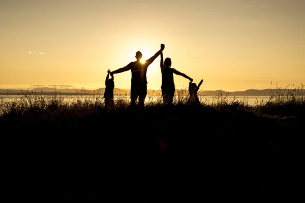 Familia de cuatro al atardecer sombra negro retroiluminado —  Fotos de Stock