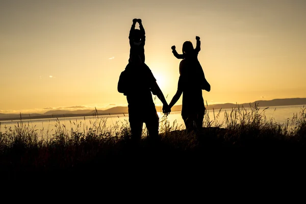 Family of four at sunset shadow black backlit — Stock Photo, Image