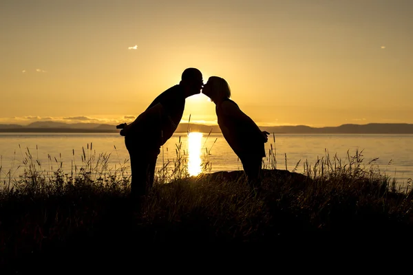 Gün batımında tropik sahilde romantik çiftlerin siluetleri. — Stok fotoğraf