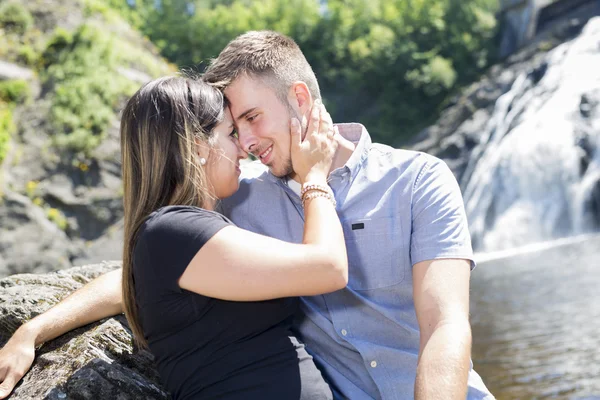 Young couple in love with waterfall on background — Stock Photo, Image