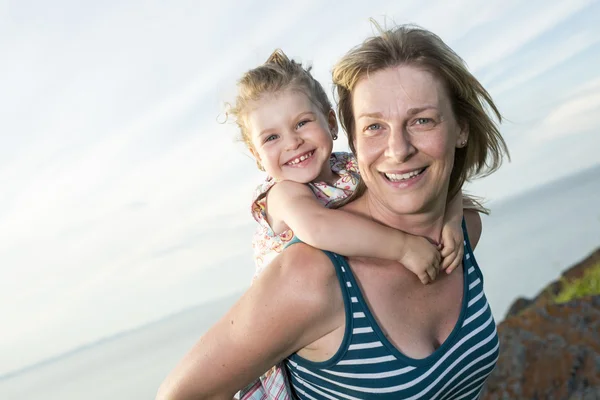 Mother and daughter on the beach side having fun — Stock Photo, Image