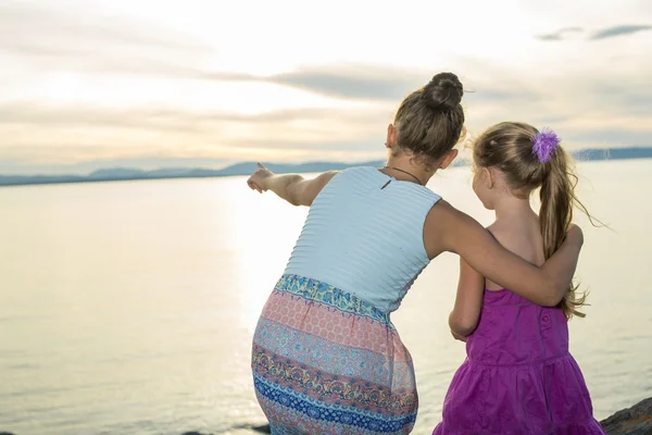 Sisters at the beach on sunset — Stock Photo, Image