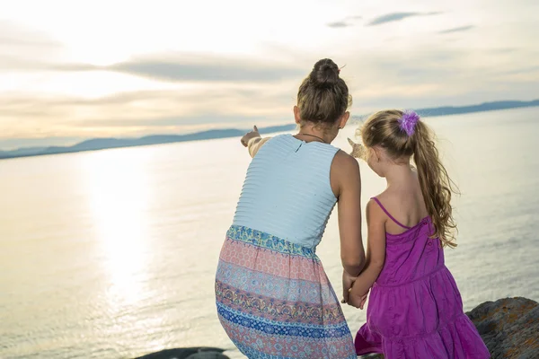 Sisters at the beach on sunset — Stock Photo, Image