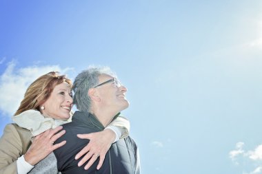 Portrait of happy senior couple in winter season clipart