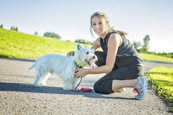 Gyönyörű fiatal nő, jogging a kutyájával — Stock Fotó