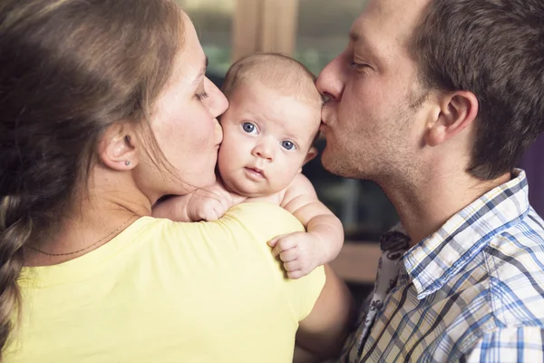 Orgulhosos pais segurando bebê no quarto — Fotografia de Stock